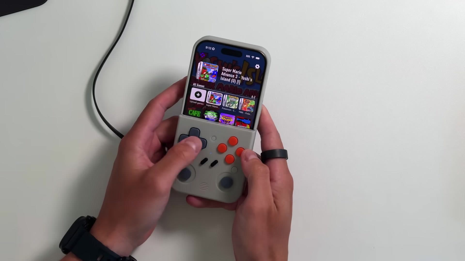 The same gray case with its physical controller below the iPhone display in play position